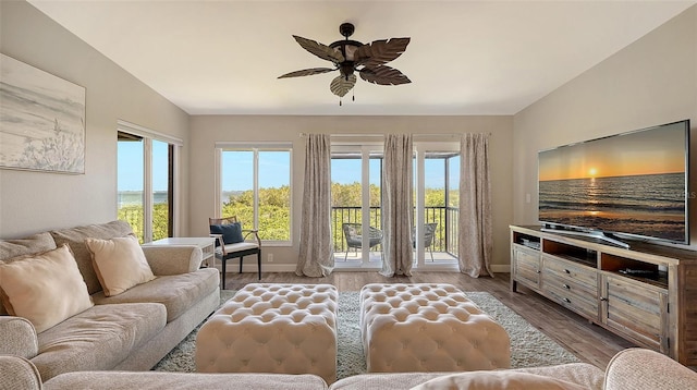 living area with light wood finished floors, plenty of natural light, and vaulted ceiling