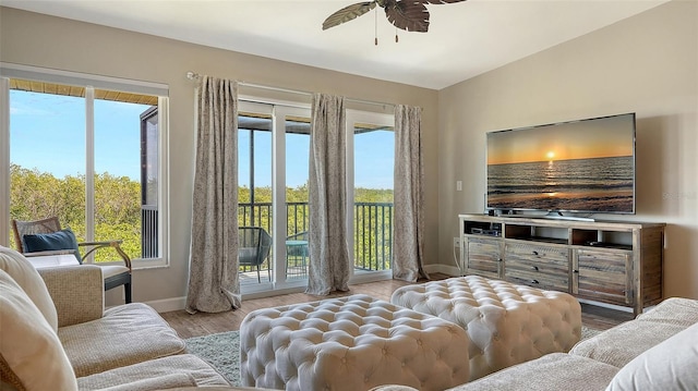 bedroom featuring baseboards, access to outside, multiple windows, and light wood-style floors