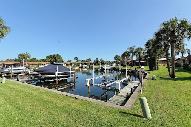 dock area featuring a water view, a lawn, and boat lift