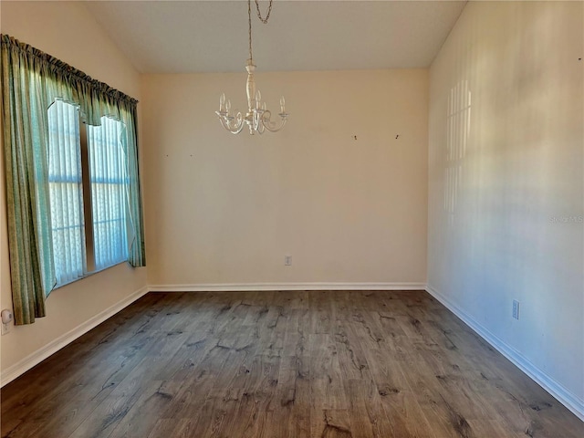 unfurnished room with hardwood / wood-style floors and a notable chandelier