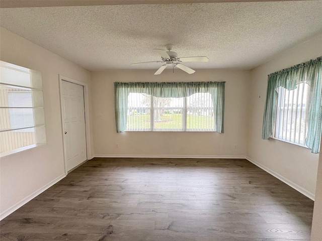 empty room featuring dark wood-type flooring, ceiling fan, and a textured ceiling