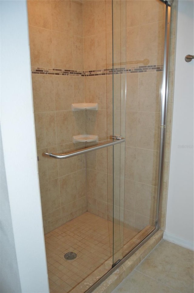 bathroom with tile patterned flooring and walk in shower