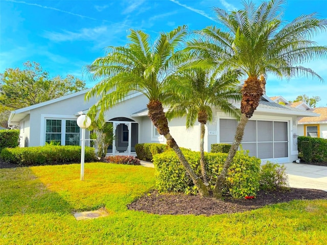 ranch-style house with concrete driveway, a front lawn, an attached garage, and stucco siding