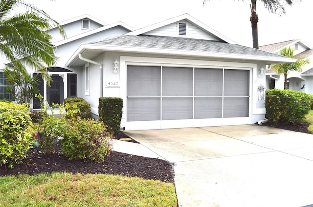 single story home with a garage, driveway, roof with shingles, and stucco siding