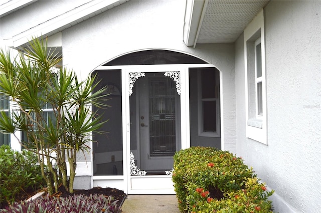 view of exterior entry featuring stucco siding