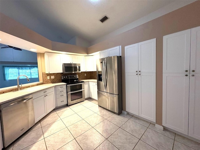 kitchen with stainless steel appliances, white cabinetry, and a sink