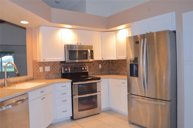 kitchen featuring appliances with stainless steel finishes, white cabinets, and a sink