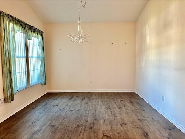 unfurnished dining area featuring baseboards, vaulted ceiling, wood finished floors, and a notable chandelier