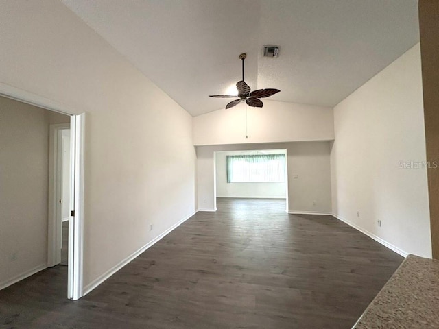 spare room with ceiling fan, dark wood-style flooring, visible vents, baseboards, and vaulted ceiling