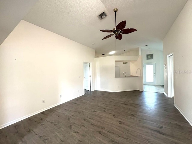 unfurnished living room with ceiling fan, a textured ceiling, visible vents, and dark wood-type flooring