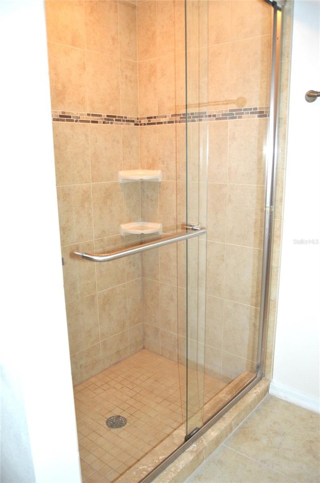 bathroom with tile patterned flooring and a shower stall