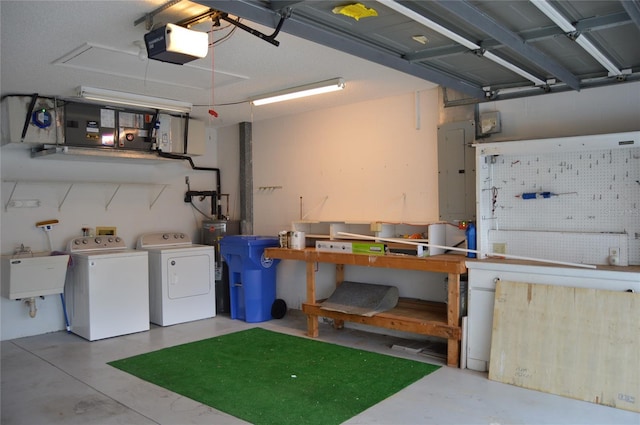 interior space with a workshop area, a garage door opener, washing machine and dryer, a sink, and electric panel