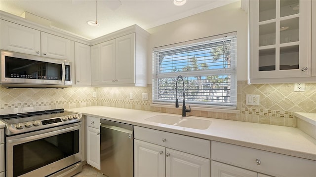 kitchen featuring stainless steel appliances, a sink, and white cabinets