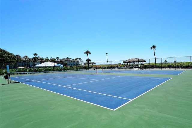 view of tennis court featuring fence