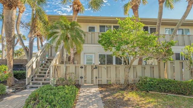 view of building exterior with a fenced front yard and stairs