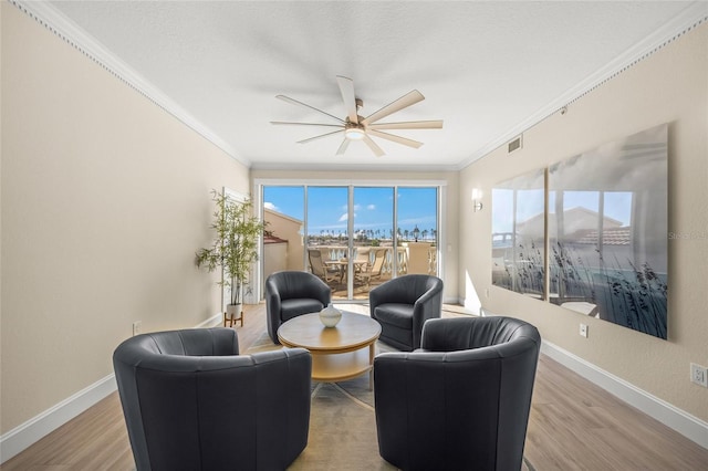 interior space with hardwood / wood-style flooring, ornamental molding, and ceiling fan