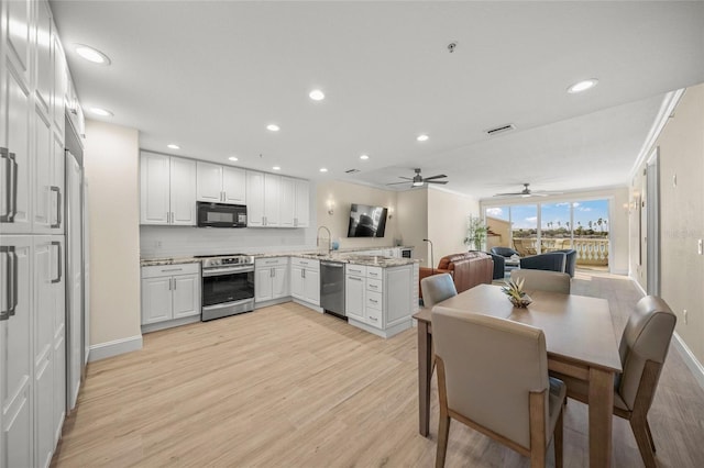 kitchen featuring sink, white cabinets, light stone counters, light hardwood / wood-style floors, and stainless steel appliances