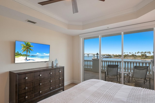 bedroom featuring wood-type flooring, ornamental molding, access to exterior, ceiling fan, and a tray ceiling