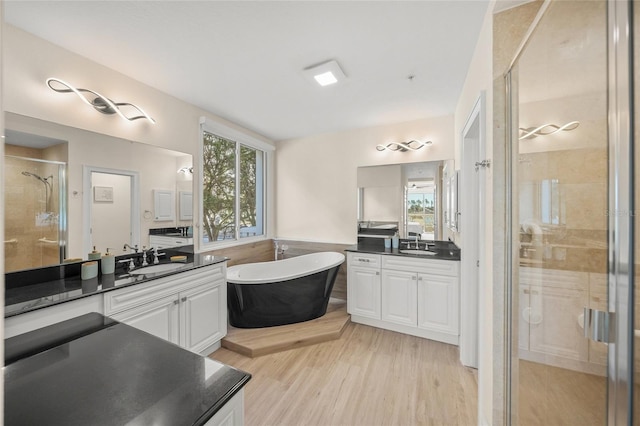 bathroom with vanity, independent shower and bath, and wood-type flooring