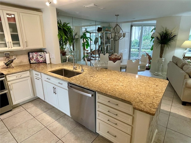 kitchen featuring sink, white cabinetry, stainless steel dishwasher, and kitchen peninsula