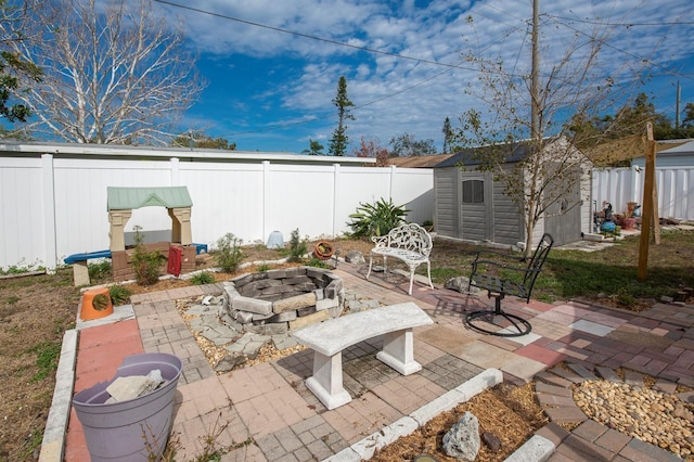 view of patio with an outdoor fire pit and a storage unit