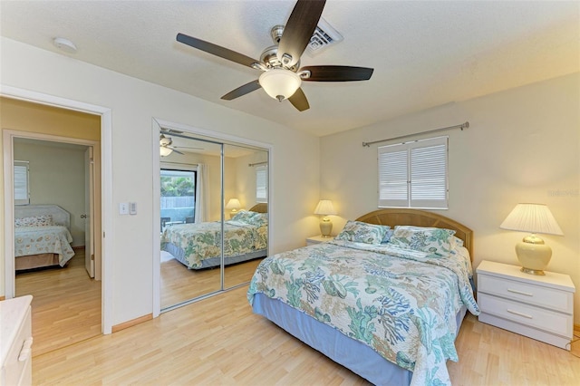 bedroom featuring ceiling fan, a textured ceiling, a closet, and light hardwood / wood-style flooring