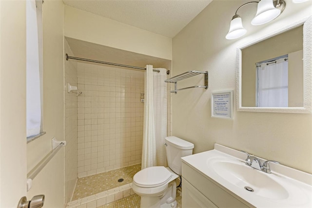 bathroom with tile patterned flooring, curtained shower, a textured ceiling, toilet, and vanity