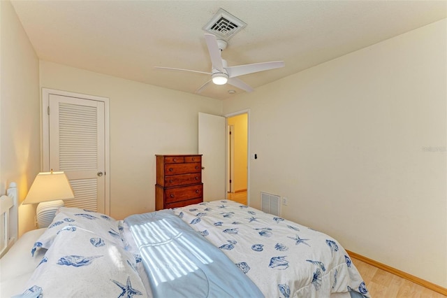 bedroom featuring ceiling fan, wood-type flooring, and a closet