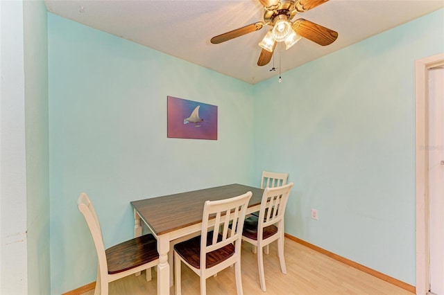 dining area with ceiling fan and light hardwood / wood-style flooring