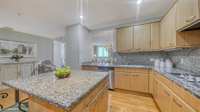 kitchen featuring sink, a breakfast bar, dishwasher, a center island, and light hardwood / wood-style floors