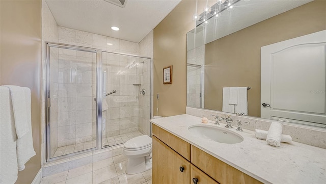 bathroom featuring tile patterned flooring, vanity, a textured ceiling, a shower with shower door, and toilet