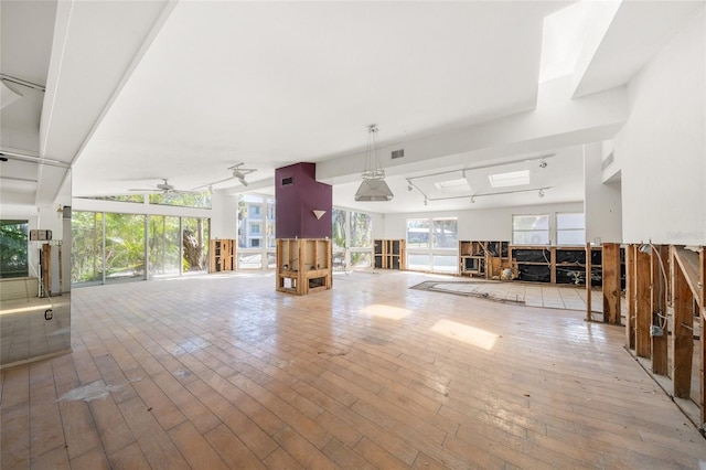 miscellaneous room featuring ceiling fan, a healthy amount of sunlight, and light hardwood / wood-style floors