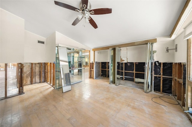 spare room featuring ceiling fan, lofted ceiling, and light hardwood / wood-style flooring