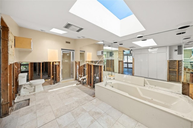 bathroom with a bathing tub, toilet, and a skylight