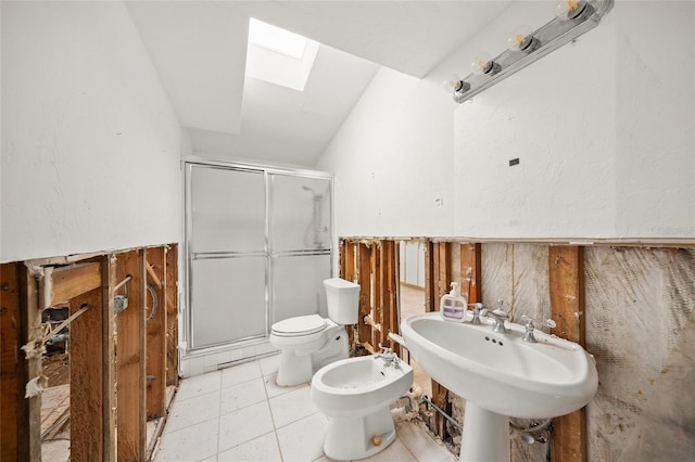 bathroom featuring lofted ceiling with skylight, a shower with shower door, toilet, a bidet, and tile patterned floors