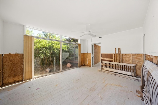 unfurnished sunroom featuring ceiling fan