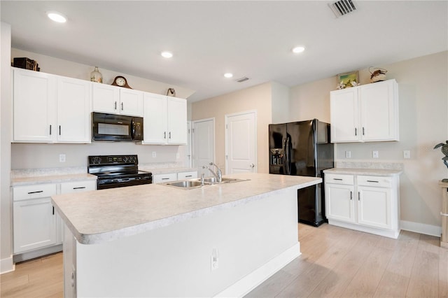 kitchen featuring sink, black appliances, light hardwood / wood-style flooring, a center island with sink, and white cabinets