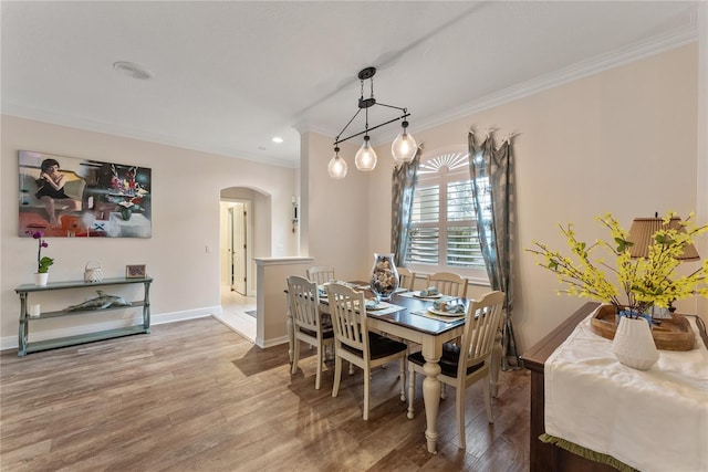 dining area with wood-type flooring and ornamental molding