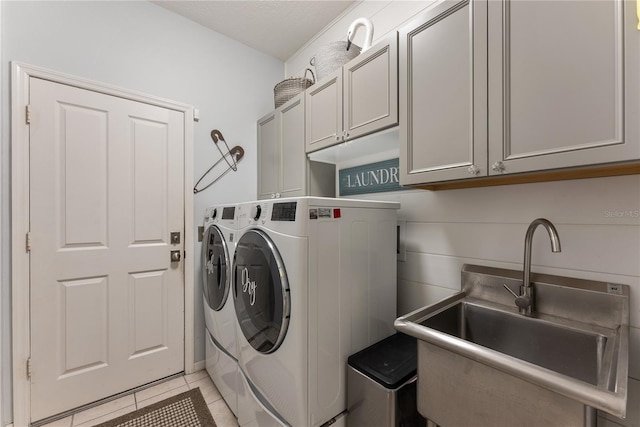 washroom with independent washer and dryer, cabinets, light tile patterned flooring, and sink