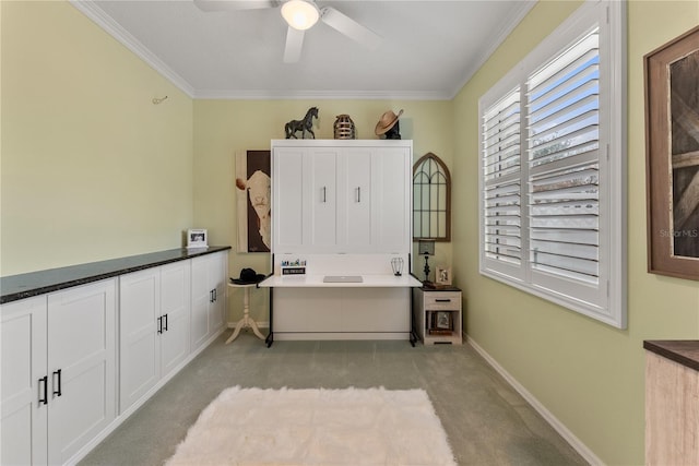 carpeted home office featuring crown molding and ceiling fan