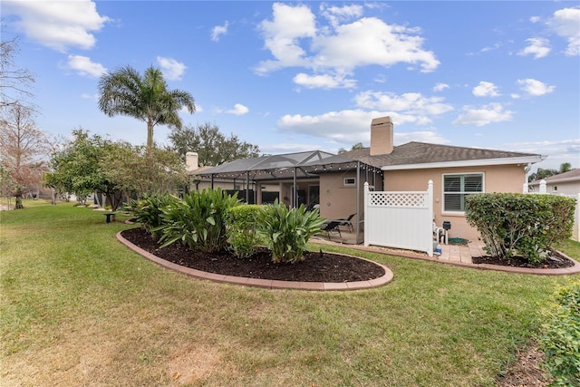 rear view of house with a lanai and a yard