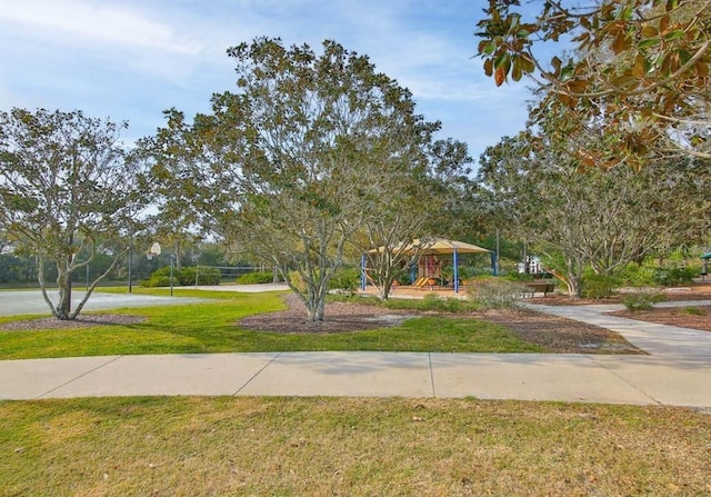 view of property's community featuring a lawn and volleyball court