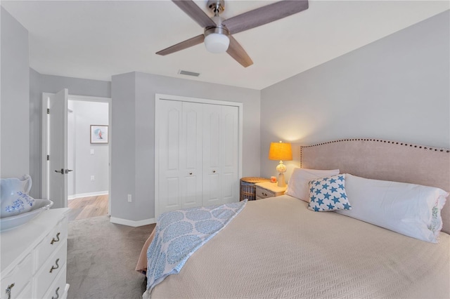 bedroom featuring ceiling fan, light colored carpet, and a closet