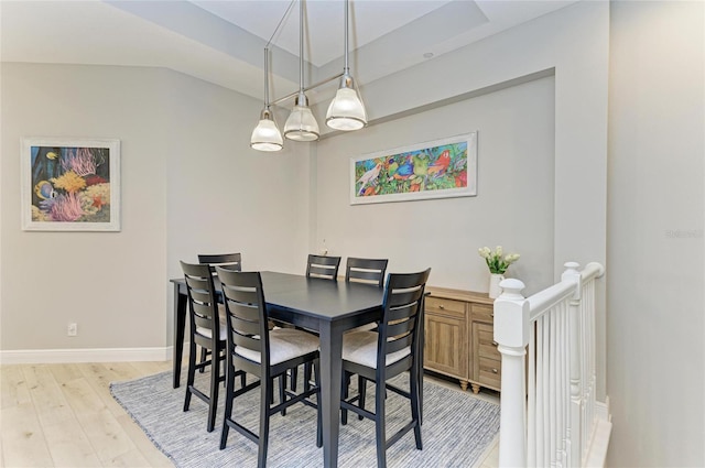 dining area with vaulted ceiling and light hardwood / wood-style floors