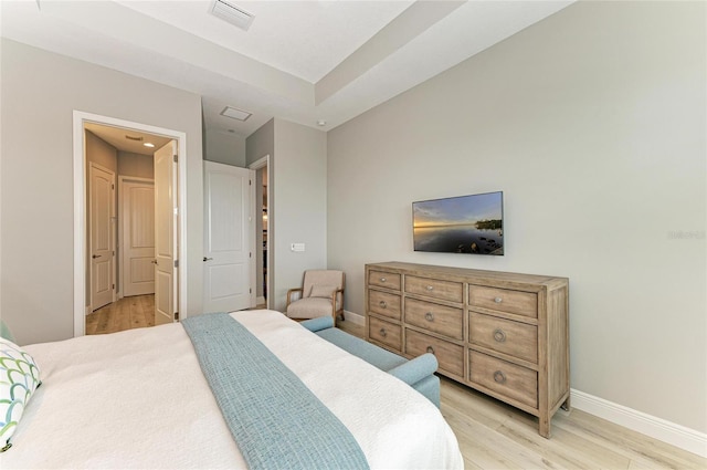 bedroom with light hardwood / wood-style floors and ensuite bathroom