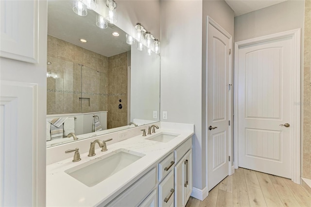 bathroom featuring a tile shower, hardwood / wood-style floors, and vanity