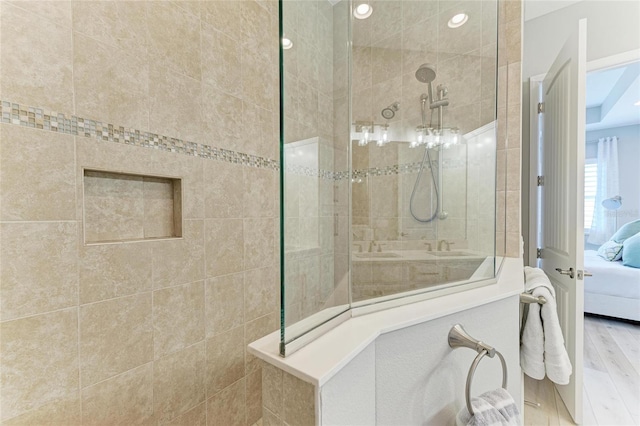 bathroom with hardwood / wood-style flooring and tiled shower