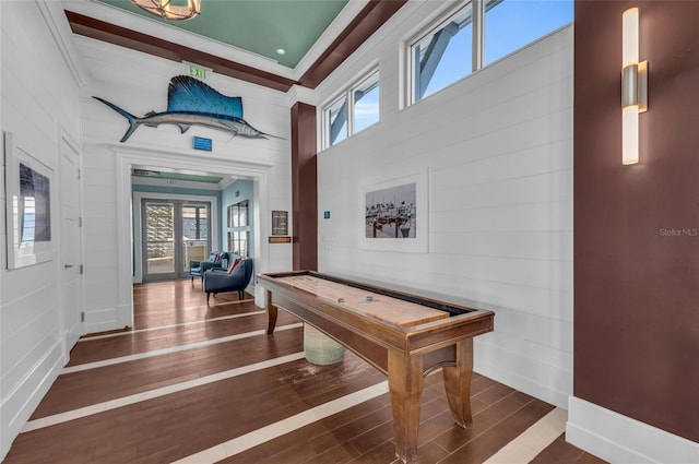 rec room with dark hardwood / wood-style flooring and ornamental molding