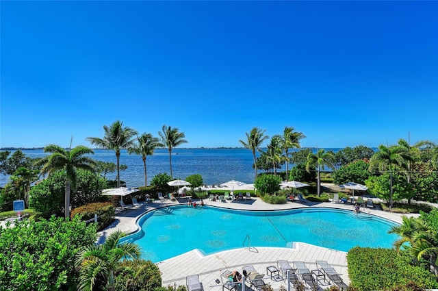 view of pool with a water view and a patio