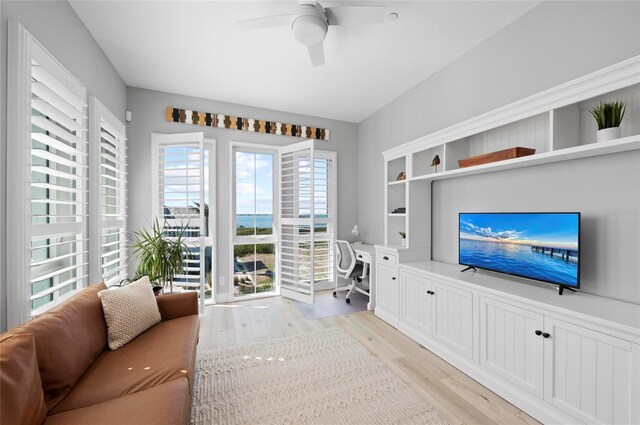 living room featuring ceiling fan, built in desk, and light wood-type flooring